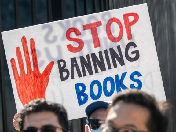 Protesters carry sign that says "Stop Banning Books"