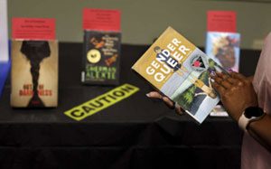 A woman examines the book Gender Queer
